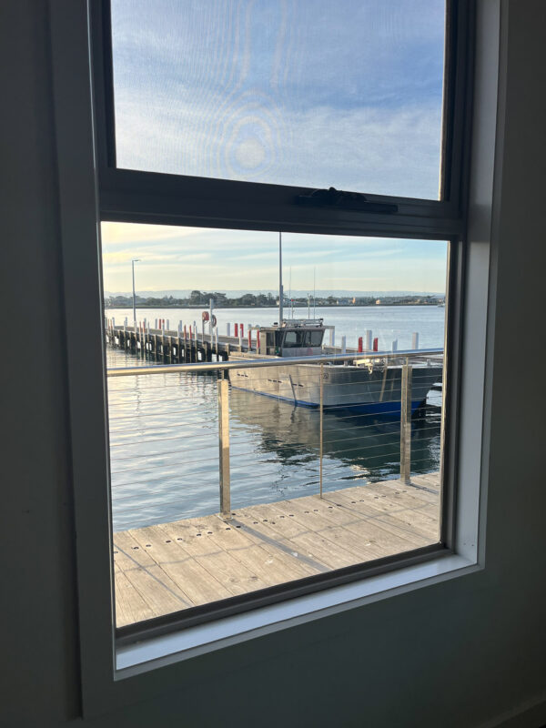 Looking out the window to boats moored at Port Albert