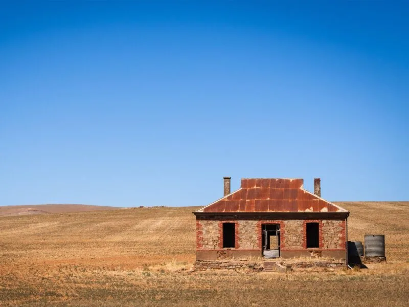 Abandoned stone house in Burra, South Australia, under a clear blue sky.